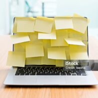 Laptop screen covered by group of yellow adhesive notes