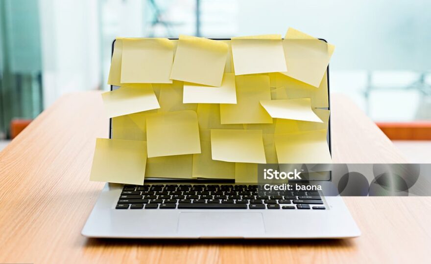 Laptop screen covered by group of yellow adhesive notes